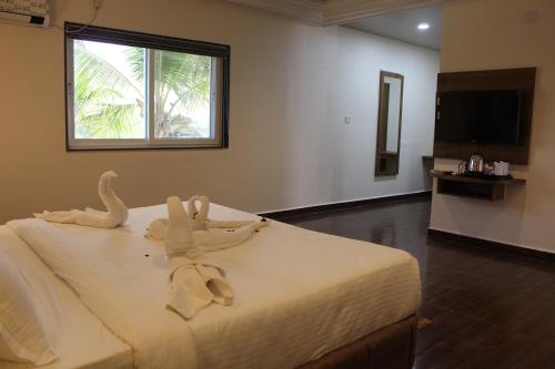 a bedroom with a bed with a towel on it at Flamingo Club and Resort Una 3 Km Away from Diu Check Post in Diu