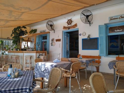 a restaurant with two tables and chairs with blue and white checks at Barbaressa in Tolo