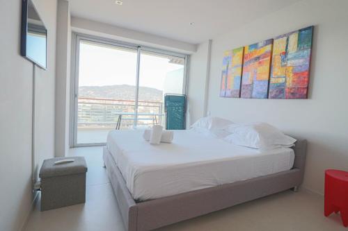 een slaapkamer met een bed en een groot raam bij LA MER Breathtaking sea view luxurious design apartment in Cannes
