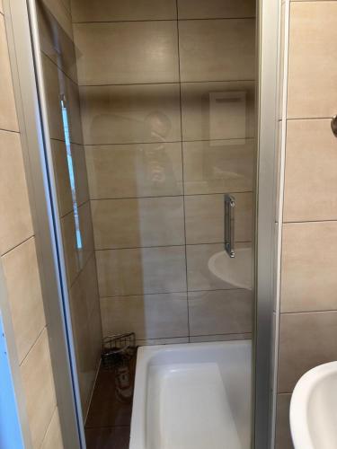 a bathroom with a shower and a tub and a sink at main Appartments Frankfurt Airport in Kelsterbach