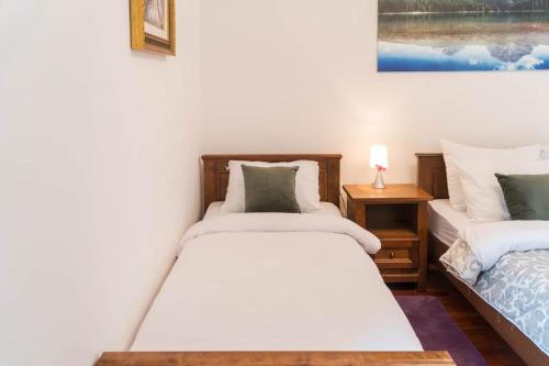 Un dormitorio con dos camas y una lámpara sobre una mesa. en APARTMAN LARA, en Žabljak