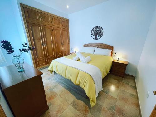 a bedroom with a bed with a yellow bedspread at APARTAMENTOs PONDOS in Linares