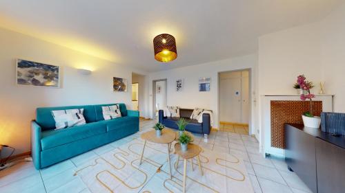 un salon avec un canapé bleu et une cheminée dans l'établissement Gîte des Bains PARKING HYPERCENTRE 6-8personnes, à Colmar