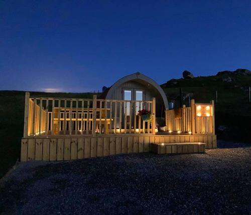 a wooden fence in front of a house at night at Meall Ard Self Catering Pod - Isle of South Uist in Pollachar