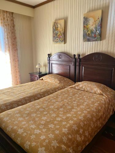 a bedroom with two beds and two paintings on the wall at Marianna's Home Accommodation in Karpenision