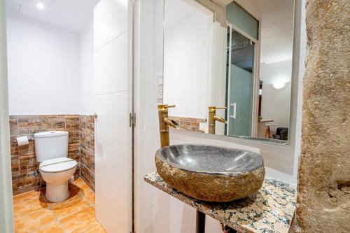 a bathroom with a stone sink and a toilet at Planta baja en la muralla romana junto a la Catedral in Tarragona