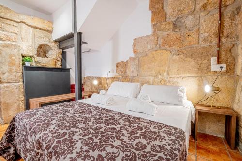 a bedroom with a large bed in a brick wall at Planta baja en la muralla romana junto a la Catedral in Tarragona