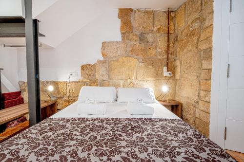 - une chambre avec un grand lit dans un mur en briques dans l'établissement Planta baja en la muralla romana junto a la Catedral, à Tarragone