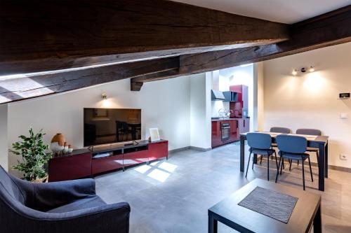 Apartamentos Los Edules في Treceño: غرفة معيشة مع طاولة وكراسي وتلفزيون