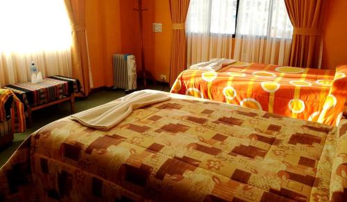 a hotel room with two beds and a window at Hotel Utama in Copacabana