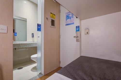 una camera ospedaliera con un letto e un bagno di FAST SLEEP Guarulhos by Slaviero Hotéis a Guarulhos