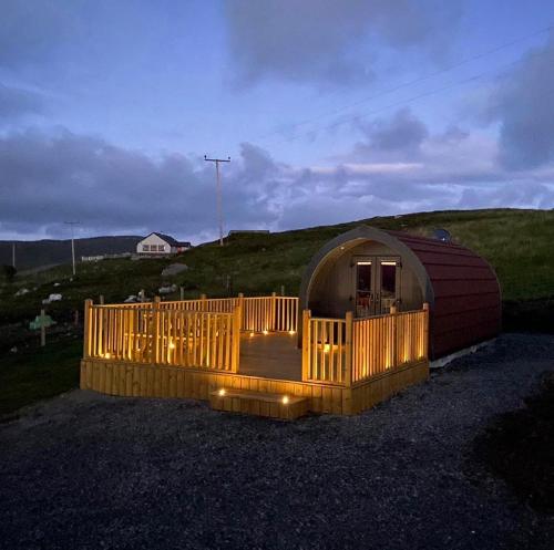 a yurt with a wooden deck in a field at Meall Ard Self Catering Pod - Isle of South Uist in Pollachar