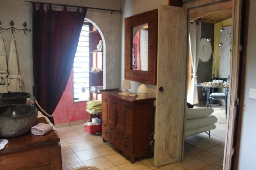 baño con lavabo y armario de madera en LA LIANE DE JADE 974-Lodge Le Palissandre - jacuzzi privatif - piscine, en Le Bois de Nèfles
