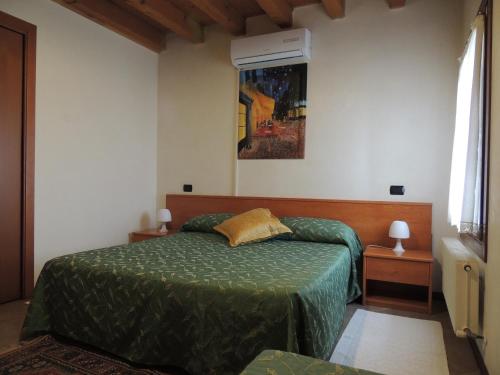 um quarto com uma cama com um edredão verde em Country House Country Club em Noghera