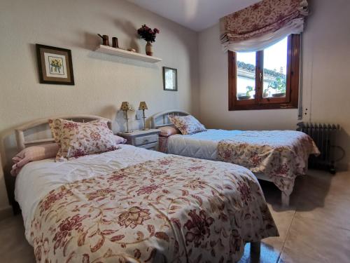 a bedroom with two beds and a window at Casa Alfonso Toledo Más que una casa un hogar in Toledo