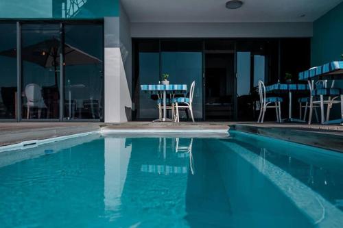 a swimming pool with a table and chairs in a building at 65onCliff in Gansbaai