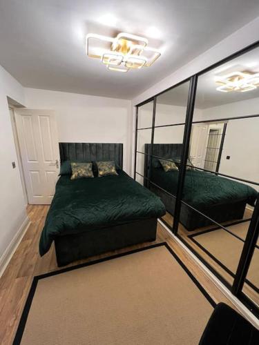 a bedroom with a green bed and a couch at GoldFlamingo in Mitcham