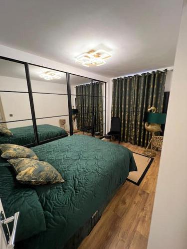 1 dormitorio con 1 cama verde en una habitación en GoldFlamingo en Mitcham