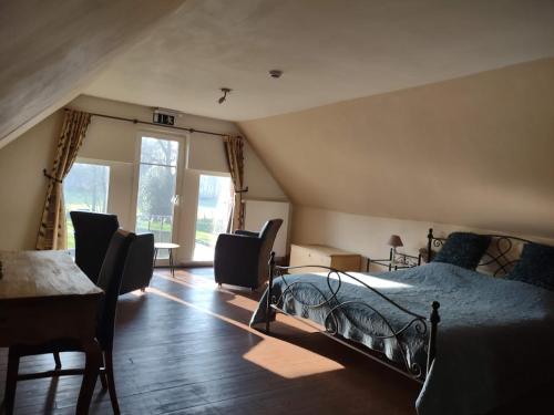 a bedroom with a bed and a table and chairs at Dielpenhof in Zedelgem