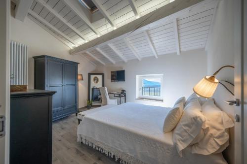um quarto com uma cama branca e uma janela em Agriturismo Maison 1933 em Caprino Veronese