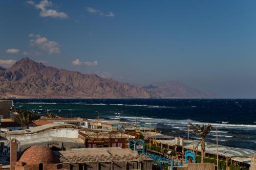 ダハブにあるAl Deira Dahab Hotelの山々を背景に海を望む