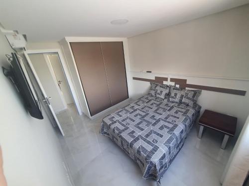 Un dormitorio con una cama y una mesa. en Lindo apt. Praia do Forte vista mar, 3qt, 3vgs (Barra Mares XX)., en Cabo Frío