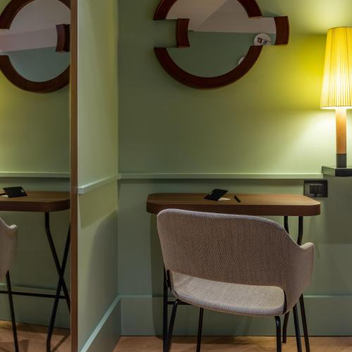 a table and chairs in a room with a lamp at Urban Hive Milano in Milan