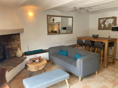 ein Wohnzimmer mit einem Sofa und einem Tisch in der Unterkunft Petite Maison en Provence in Plaisians