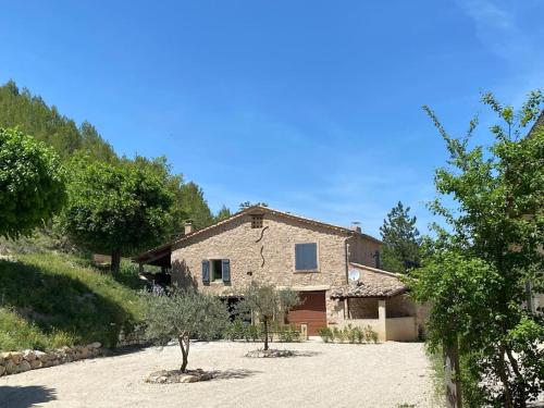 ein Steinhaus mit einer Einfahrt davor in der Unterkunft Petite Maison en Provence in Plaisians