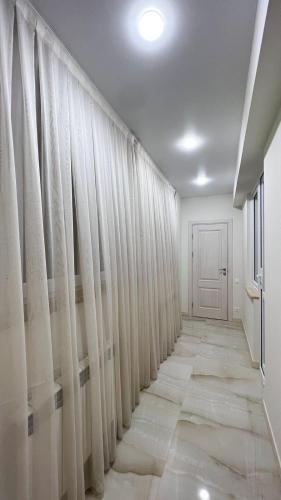 a hallway with white curtains and a door at La Casa de Armenie in Yerevan
