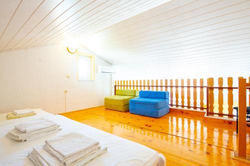 a room with a bed and two colorful chairs at Apartment Kelly in Novalja