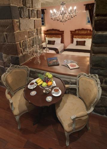 a room with a table and chairs and a bedroom at Aranwa Cusco Boutique Hotel in Cusco