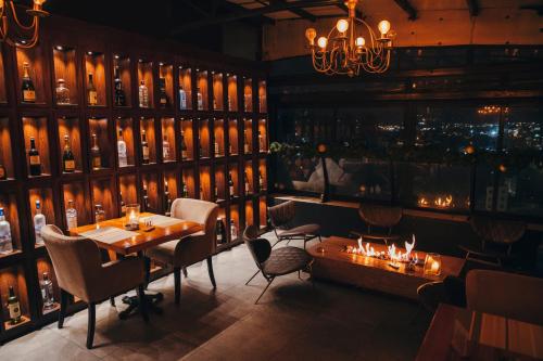 a restaurant with a table and chairs and a wall of wine bottles at Ankars Suites & Hotel in Ramallah