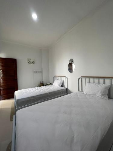 1 Schlafzimmer mit 2 Betten und weißer Bettwäsche in der Unterkunft villa skye in Tarogong