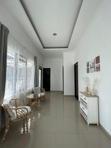 ein Wohnzimmer mit weißen Wänden sowie einem Tisch und Stühlen in der Unterkunft villa skye in Tarogong