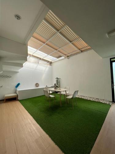 Zimmer mit einem Tisch, Stühlen und einem grünen Teppich in der Unterkunft villa skye in Tarogong