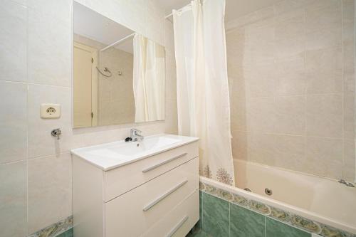 een badkamer met een wastafel, een spiegel en een bad bij Estrella 1 Spaniahome in Albir
