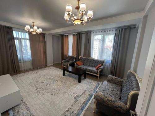 a living room with couches and a chandelier at 3-room elite apartment Alexandria in Bishkek