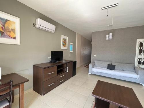 a room with a bed and a desk with a tv at Thara Real Estate in Sowayma