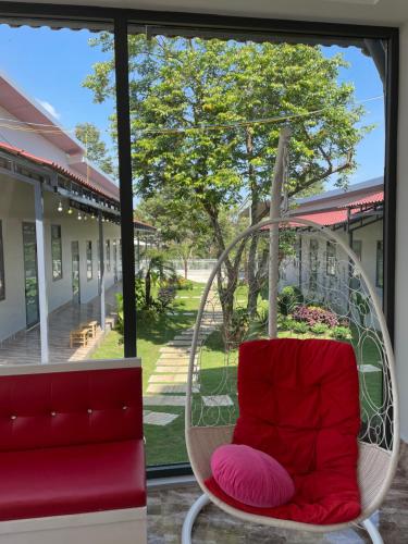 a hanging chair in front of a window at Nam Anh Homestay in Bao Loc