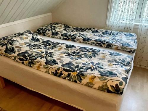 a bed with a blanket on top of it at Holiday home Sæbøvik in Sæbøvik