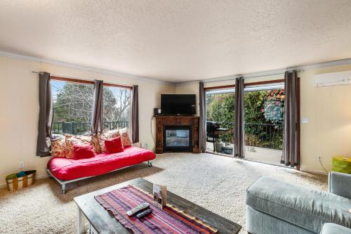 un soggiorno con divano rosso e camino di Sandy Cottage a Lincoln City