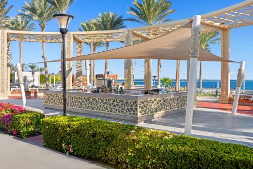 a gazebo at the beach with palm trees and the ocean at Rixos Premium Seagate in Sharm El Sheikh