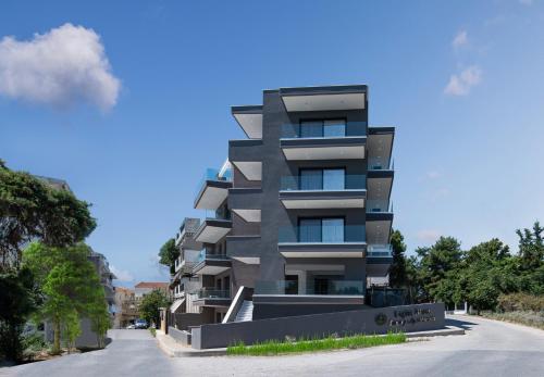 a tall building on the side of a street at Light Blue Hotel in Nea Kalikratia
