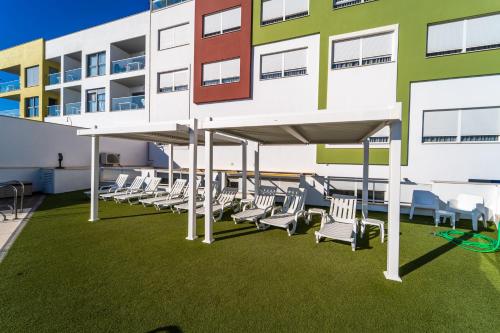 a group of chairs on a lawn in front of a building at Vistamar Hotel Luxury Wellness By DLV -Adults Only- in Villajoyosa