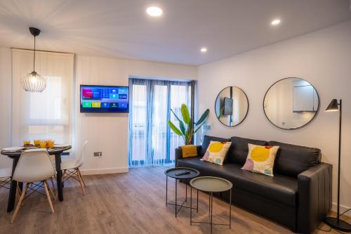 a living room with a black couch and a table at Trendy Homes Puerta Purchena in Almería