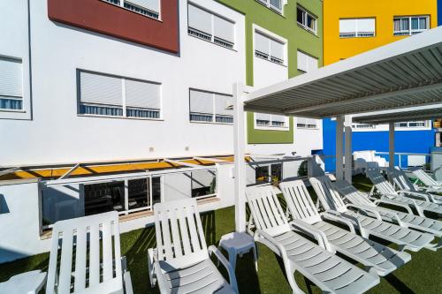 a row of white chairs on the balcony of a building at Vistamar Hotel Luxury Wellness By DLV -Adults Only- in Villajoyosa