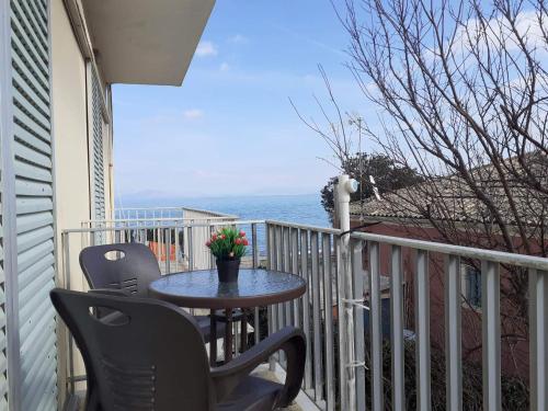 einen Tisch und Stühle auf einem Balkon mit Meerblick in der Unterkunft Dimitris Apartments Messongi in Mesongi