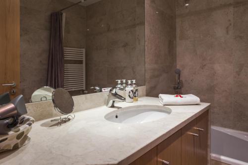 a bathroom with a sink and a mirror at RENT4REST LISBON PARQUE DAS NAÇÕES 17Th FLOOR RIVER VIEW in Lisbon