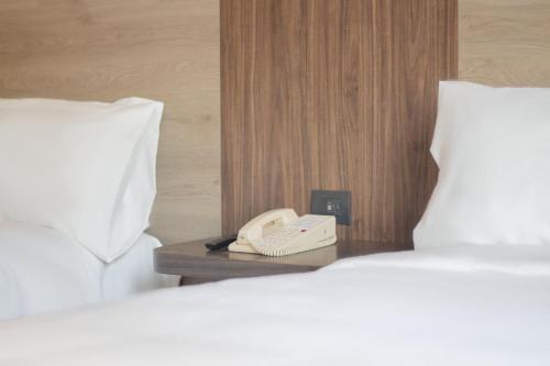 a phone sitting on a table between two beds at Holiday Inn Express Mexico City Satelite by IHG in Mexico City